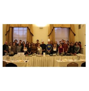 A group of German Club members gathered for a group picture behind a banquet table.